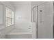 Bathroom with a white tiled shower with glass doors and a separate soaking tub under a window at 10462 Lucaya Dr, Tampa, FL 33647