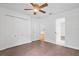 A bright bedroom featuring a ceiling fan, closet doors, and view to an ensuite bathroom at 10462 Lucaya Dr, Tampa, FL 33647