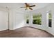 Bedroom with hardwood floors, ceiling fan, closet, and multiple windows overlooking trees at 10462 Lucaya Dr, Tampa, FL 33647