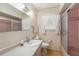 Cozy bathroom features a single sink vanity, decorative mirror, and a shower with glass doors at 105 Melrose Dr, Safety Harbor, FL 34695