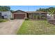 Charming brick home featuring a well-maintained lawn, mature landscaping, and an attached two-car garage at 105 Melrose Dr, Safety Harbor, FL 34695