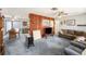 Open-concept living area featuring a wood accent wall, ceiling fan, and seamless flow to dining and kitchen at 105 Melrose Dr, Safety Harbor, FL 34695