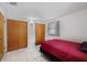 Bedroom featuring tile flooring, natural light, and double closets at 10730 Premier Ave, Port Richey, FL 34668