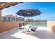 Waterfront balcony featuring a table with seating for four shaded by a large umbrella on a sunny day at 120 Brightwater Dr, Clearwater Beach, FL 33767