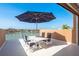 Waterfront balcony featuring a table with seating for four shaded by a large umbrella on a sunny day at 120 Brightwater Dr, Clearwater Beach, FL 33767