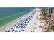 Expansive beach view showcasing blue umbrellas, palm trees, and beachfront buildings at 120 Brightwater Dr, Clearwater Beach, FL 33767