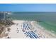Breath-taking beach view showcasing blue umbrellas, palm trees, and oceanfront at 120 Brightwater Dr, Clearwater Beach, FL 33767