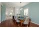 Open-concept dining room with glass-top table, modern lighting, and view into kitchen at 120 Brightwater Dr, Clearwater Beach, FL 33767