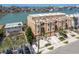 Three-story townhouse with tan stucco, small balconies, private garages, and waterfront view of canal at 120 Brightwater Dr, Clearwater Beach, FL 33767