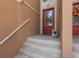Entryway showcasing a red front door, concrete steps, and light tan stucco walls at 120 Brightwater Dr, Clearwater Beach, FL 33767