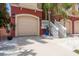Garage and entryway featuring a beige garage door, concrete driveway, and manicured landscaping at 120 Brightwater Dr, Clearwater Beach, FL 33767