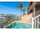 Private waterfront hot tub surrounded by lush landscaping and a secure fence at 120 Brightwater Dr, Clearwater Beach, FL 33767
