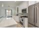 Well-lit kitchen with white cabinetry, stainless steel refrigerator, and a modern oven at 120 Brightwater Dr, Clearwater Beach, FL 33767