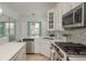 Kitchen featuring modern appliances, white cabinets, stylish backsplash, and natural light at 120 Brightwater Dr, Clearwater Beach, FL 33767