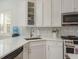 Bright kitchen showcasing white cabinetry, stainless steel appliances, and stylish backsplash at 120 Brightwater Dr, Clearwater Beach, FL 33767