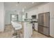 Modern kitchen with white cabinets, stainless steel appliances, and a unique glass countertop island at 120 Brightwater Dr, Clearwater Beach, FL 33767