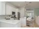 Modern kitchen with white cabinets, stainless steel appliances, and a breakfast bar overlooking the living area at 120 Brightwater Dr, Clearwater Beach, FL 33767
