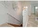 Bright staircase featuring hardwood steps, white railings, and white walls with decorative art at 120 Brightwater Dr, Clearwater Beach, FL 33767