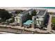 Stunning aerial view of a beachfront condo complex with a turquoise roof and ample parking at 12000 Gulf Blvd # 403-S, Treasure Island, FL 33706