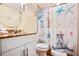 Bathroom with a vanity with granite countertop, starfish-themed shower curtain and a round mirror at 12000 Gulf Blvd # 403-S, Treasure Island, FL 33706