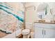 Bathroom with beach-themed shower curtain, granite countertop vanity, circular mirror, and tile shower at 12000 Gulf Blvd # 403-S, Treasure Island, FL 33706