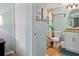 Cozy bathroom featuring wood-look flooring, beach-themed decor, a white vanity, and a shower with a charming beach curtain at 12000 Gulf Blvd # 403-S, Treasure Island, FL 33706