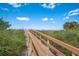 A wooden walkway leads to a pristine beach with lush vegetation at 12000 Gulf Blvd # 403-S, Treasure Island, FL 33706