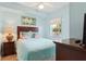 Comfortable bedroom featuring light blue walls, a plush bed, wooden furniture, and a window at 12000 Gulf Blvd # 403-S, Treasure Island, FL 33706