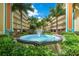 Beautiful courtyard fountain surrounded by tropical plants and multi-story buildings at 12000 Gulf Blvd # 403-S, Treasure Island, FL 33706