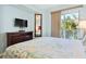 Main bedroom featuring light blue walls, a bed, a dresser, a mirror, and a private balcony at 12000 Gulf Blvd # 403-S, Treasure Island, FL 33706
