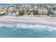 Stunning aerial view of beach home on the ocean with clear, turquoise water at 12458 1St W St, Treasure Island, FL 33706
