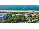 Aerial view of property with pool surrounded by lush green trees near the beach at 12458 1St W St, Treasure Island, FL 33706