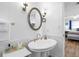 Bright bathroom featuring white wainscoting, brass fixtures, and an oval mirror at 12458 1St W St, Treasure Island, FL 33706