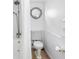 Nautical-themed bathroom with white wainscoting, porthole mirror, and brass shower fixtures at 12458 1St W St, Treasure Island, FL 33706