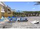 Beachside view of a blue picnic table and umbrella, with a hammock and chairs, perfect for outdoor gatherings at 12458 1St W St, Treasure Island, FL 33706