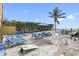 Beach area features chairs, picnic table, palm trees, a grill, and outdoor games for entertaining at 12458 1St W St, Treasure Island, FL 33706