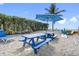 Relaxing beach setup with a blue picnic table, umbrella, hammock, and chairs, with room for games at 12458 1St W St, Treasure Island, FL 33706