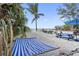 Scenic beach view featuring a hammock, picnic table, and chairs, inviting relaxation and outdoor enjoyment at 12458 1St W St, Treasure Island, FL 33706