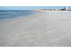 Expansive beach view with soft sand and gentle waves rolling in at 12458 1St W St, Treasure Island, FL 33706