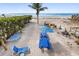 Aerial beach view featuring a private sandy area with picnic table, hammock, and grill at 12458 1St W St, Treasure Island, FL 33706