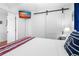 Bedroom showcasing a barn door, mounted TV, and nautical accents at 12458 1St W St, Treasure Island, FL 33706