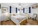 Light bedroom with a ceiling fan, wood floors, and blue curtains at 12458 1St W St, Treasure Island, FL 33706