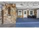 Exterior of home with stone accents, outdoor shower, and patio with seating at 12458 1St W St, Treasure Island, FL 33706