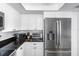 Kitchen features stainless refrigerator and microwave, white cabinets and subway tile at 12458 1St W St, Treasure Island, FL 33706