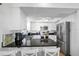 Modern kitchen featuring white cabinetry, black countertops, and stainless-steel appliances at 12458 1St W St, Treasure Island, FL 33706