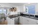 Kitchen boasts white cabinets, stainless dishwasher, granite counters, with shelves and ocean view at 12458 1St W St, Treasure Island, FL 33706