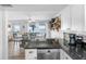 Open kitchen with dark counters, view of dining area, and scenic ocean backdrop at 12458 1St W St, Treasure Island, FL 33706