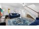 Cozy living room featuring a staircase, blue sofa, and stylish rug at 12458 1St W St, Treasure Island, FL 33706