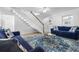 Bright living room with comfortable blue sofas, rug, and staircase at 12458 1St W St, Treasure Island, FL 33706