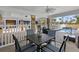 Covered outdoor seating area with a table and chairs, with a view of the pool at 12458 1St W St, Treasure Island, FL 33706